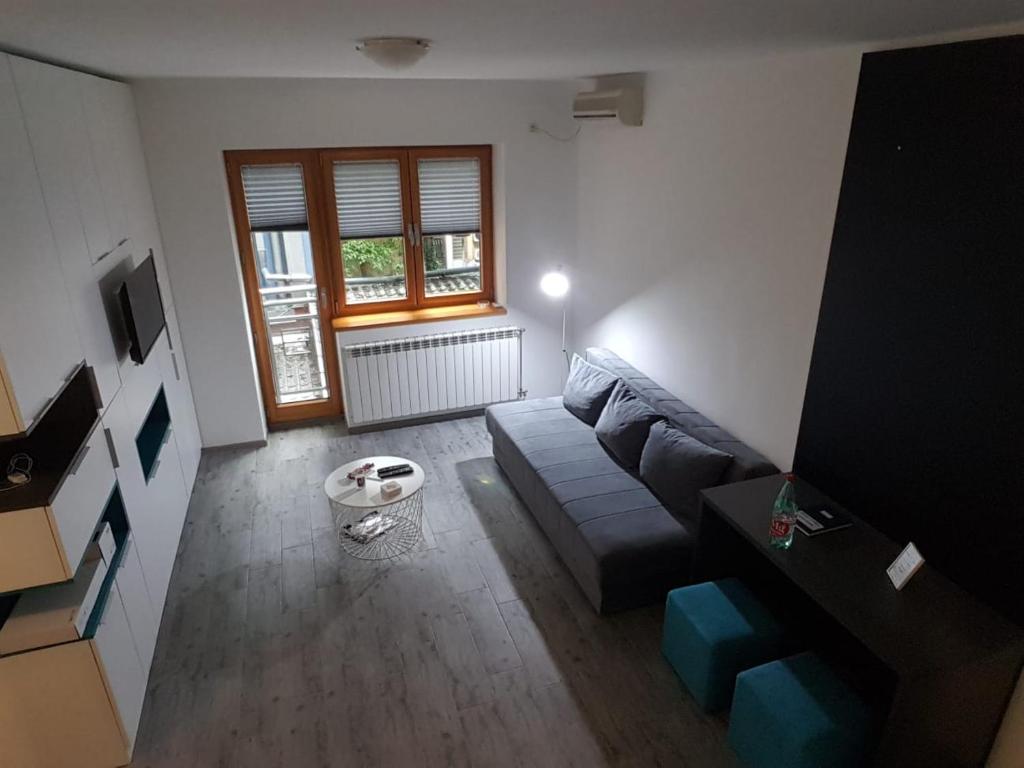 un soggiorno con divano e finestra di Apartments REST - Centar a Novi Sad