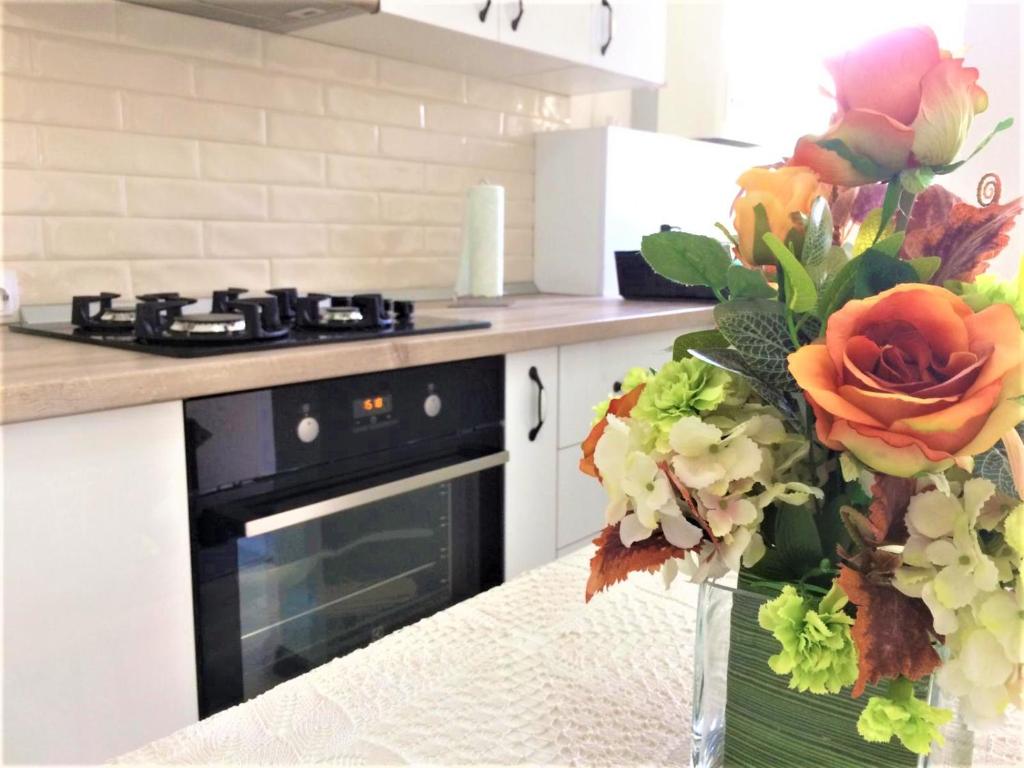 uma cozinha com um fogão e um vaso de flores em Warm Studio em Sibiu