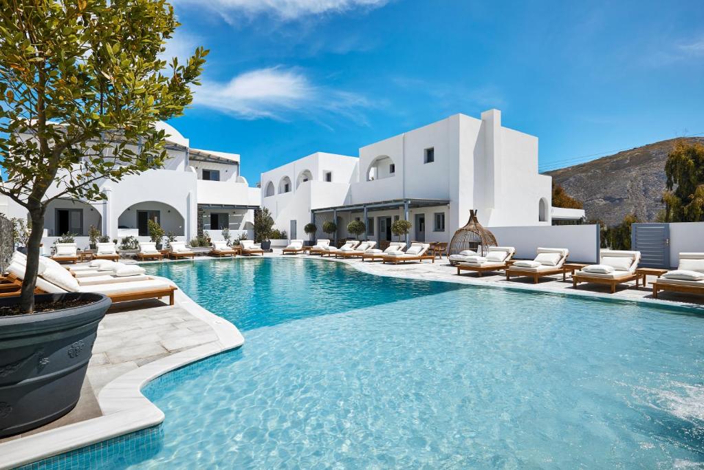 - une piscine avec des chaises longues et un complexe dans l'établissement Amara Suites Santorini, à Kamari