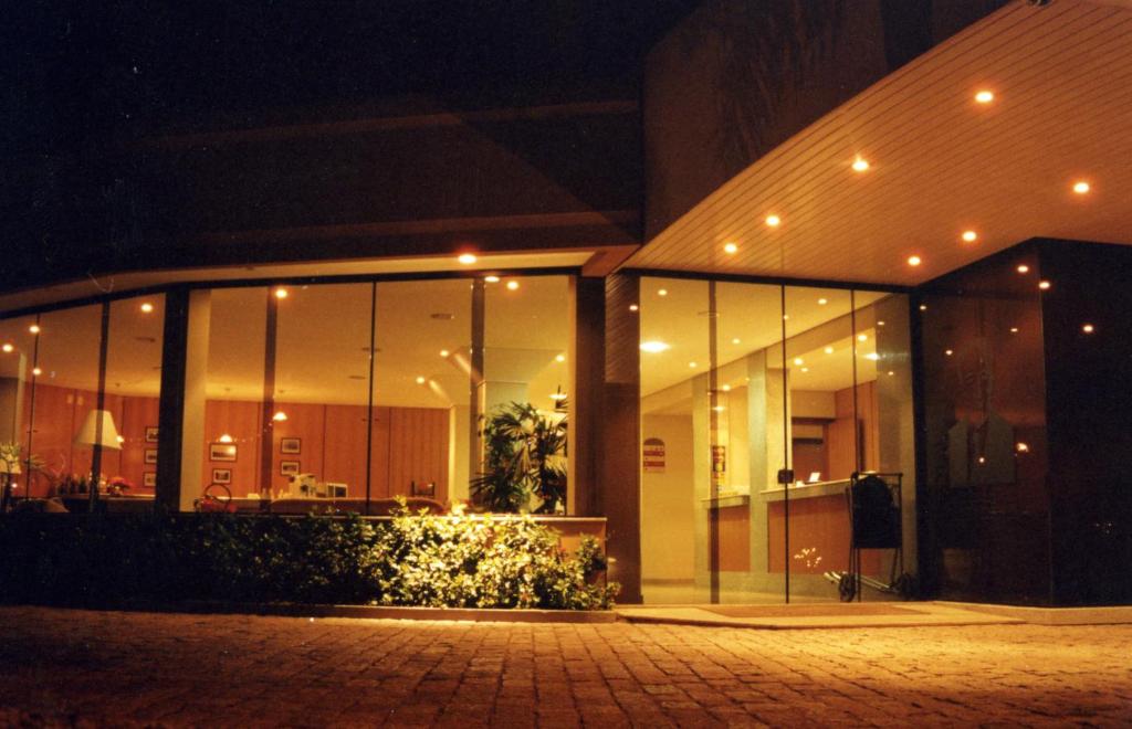 a building with large glass windows at night at Hotel O Casarão in Araras