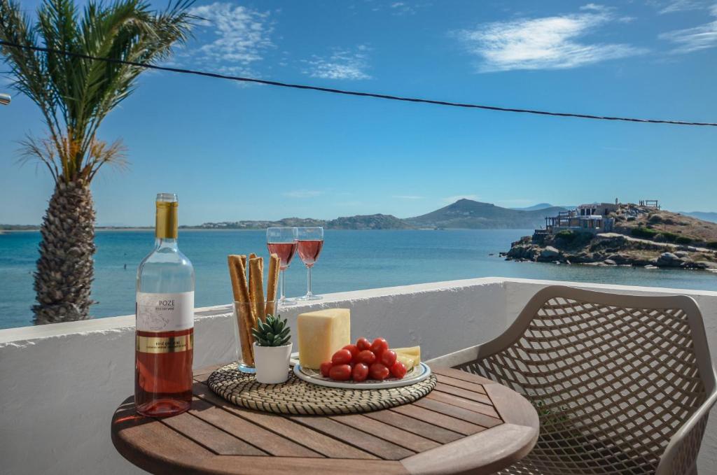 einen Tisch mit einer Flasche Wein und einem Obstteller in der Unterkunft Prestige on the beach in Naxos Chora
