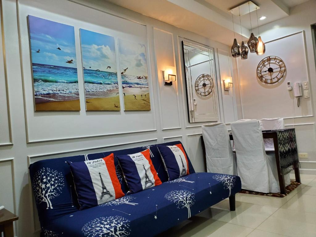 a living room with a blue couch and a table at Shell Residence Manila in Manila