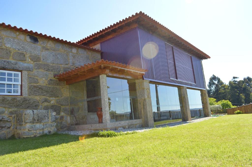una casa con una gran ventana en el lateral en Casa do Rancho - Turismo Rural en Paranhos