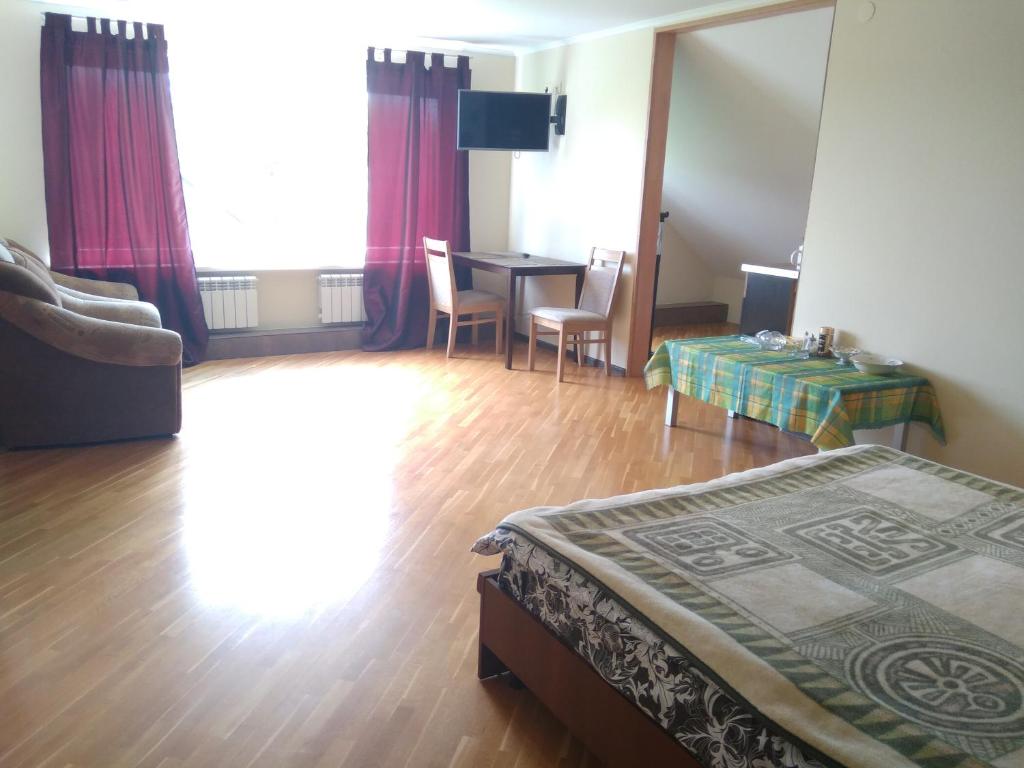 1 dormitorio con 1 cama, mesa y sillas en Room in the Country House, en Minsk
