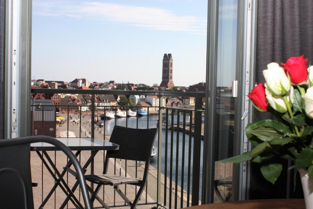 a balcony with a table and chairs and a view of the city at Appartement Altstadtblick im Ohlerich-Speicher in Wismar