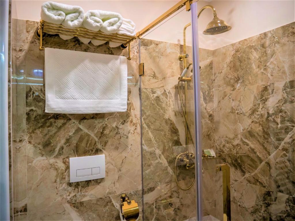 uma casa de banho com um chuveiro e uma porta de vidro em Hotel Boka em Tirana