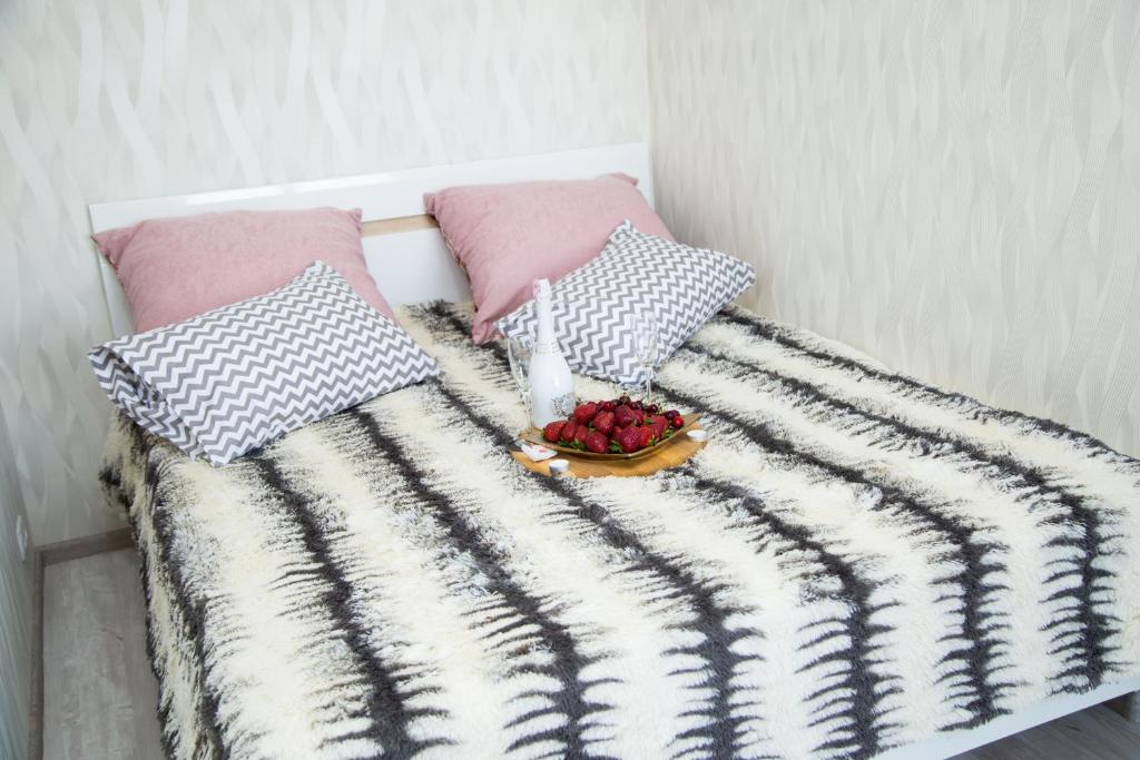 a bed with a blanket and a bowl of fruit on it at New House Comfort Apartment in Odesa