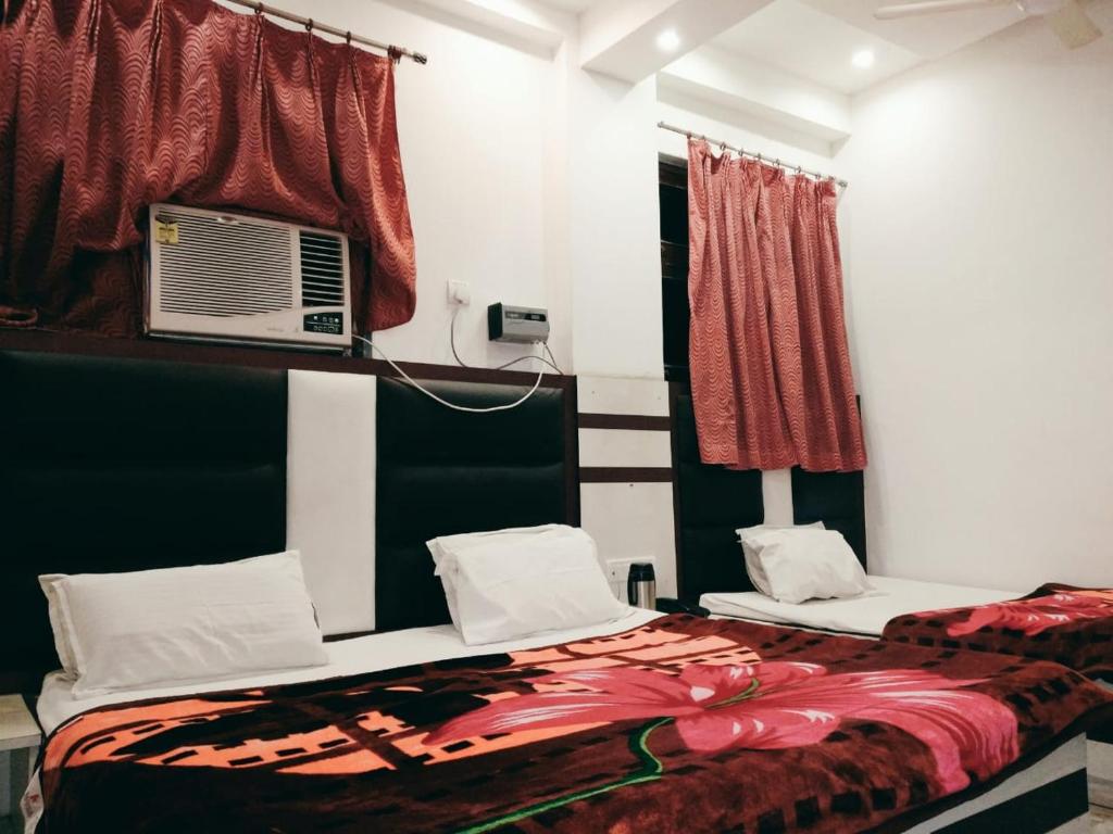 a bedroom with two beds and a air conditioner at Hotel Marwari in Agra