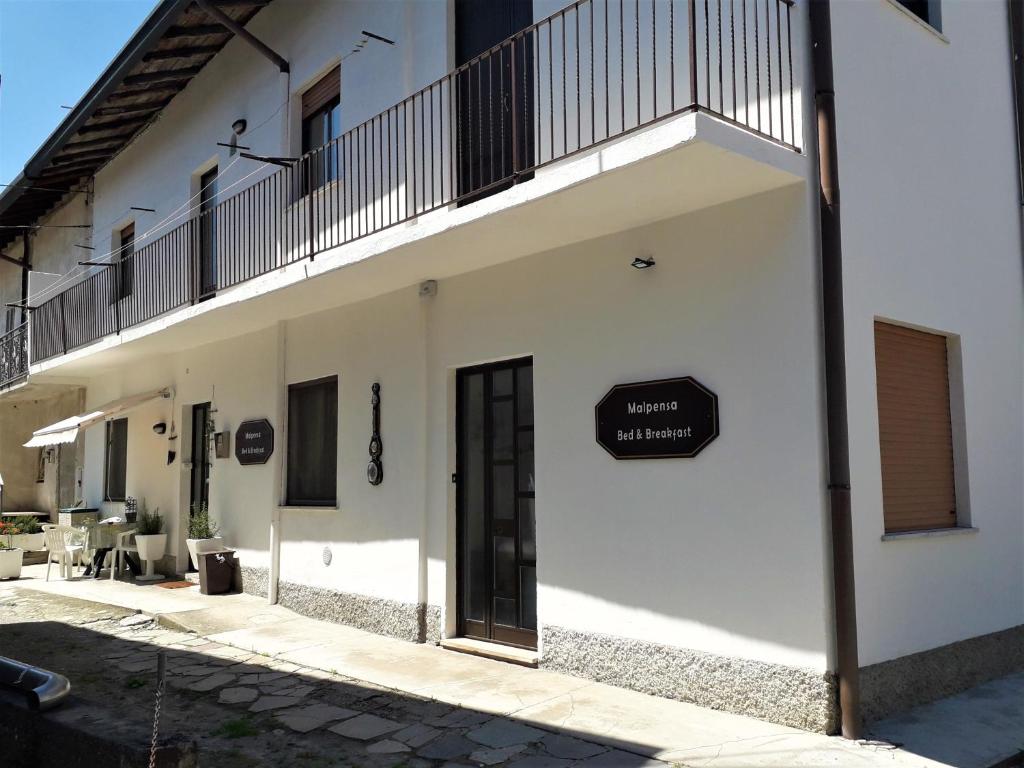 a white building with a sign on the side of it at Malpensa Bed & Breakfast in Case Nuove