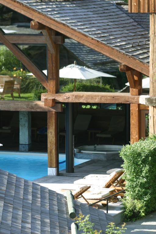 a patio with chairs and an umbrella next to a pool at Le Hameau Albert 1er in Chamonix