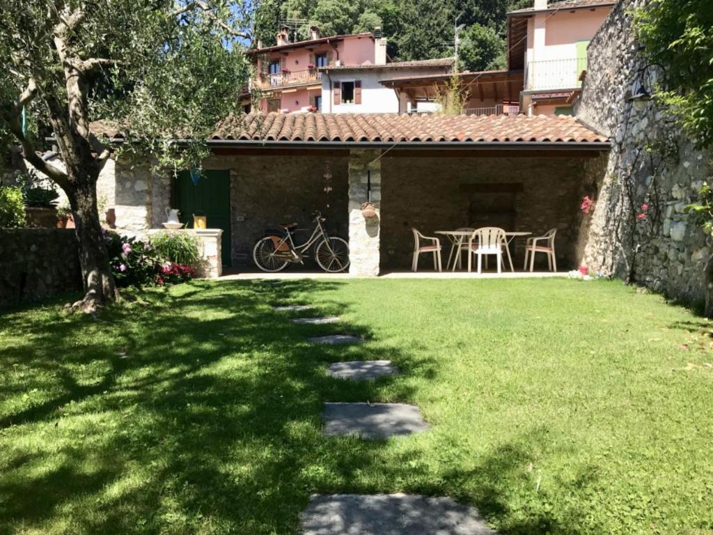 un jardín con mesa y sillas en un patio en Casa Angela, en Toscolano Maderno
