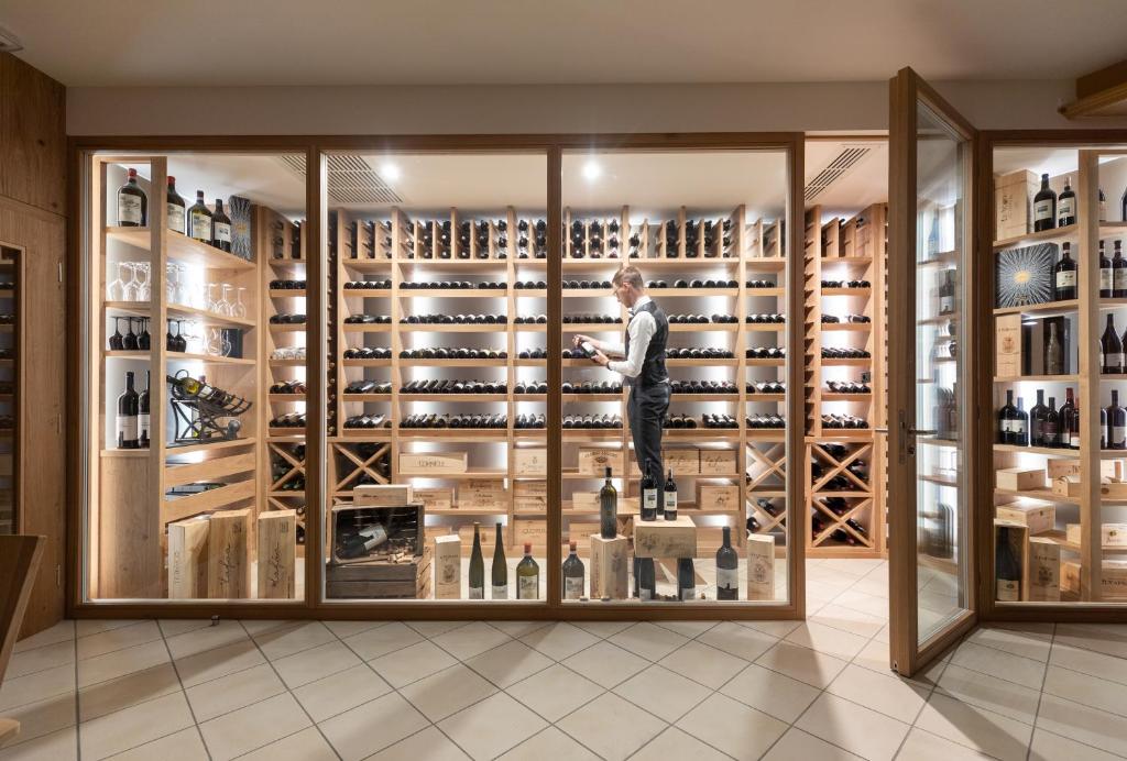 a wine cellar with a man standing in a display case at Hotel Piccolo in Obereggen