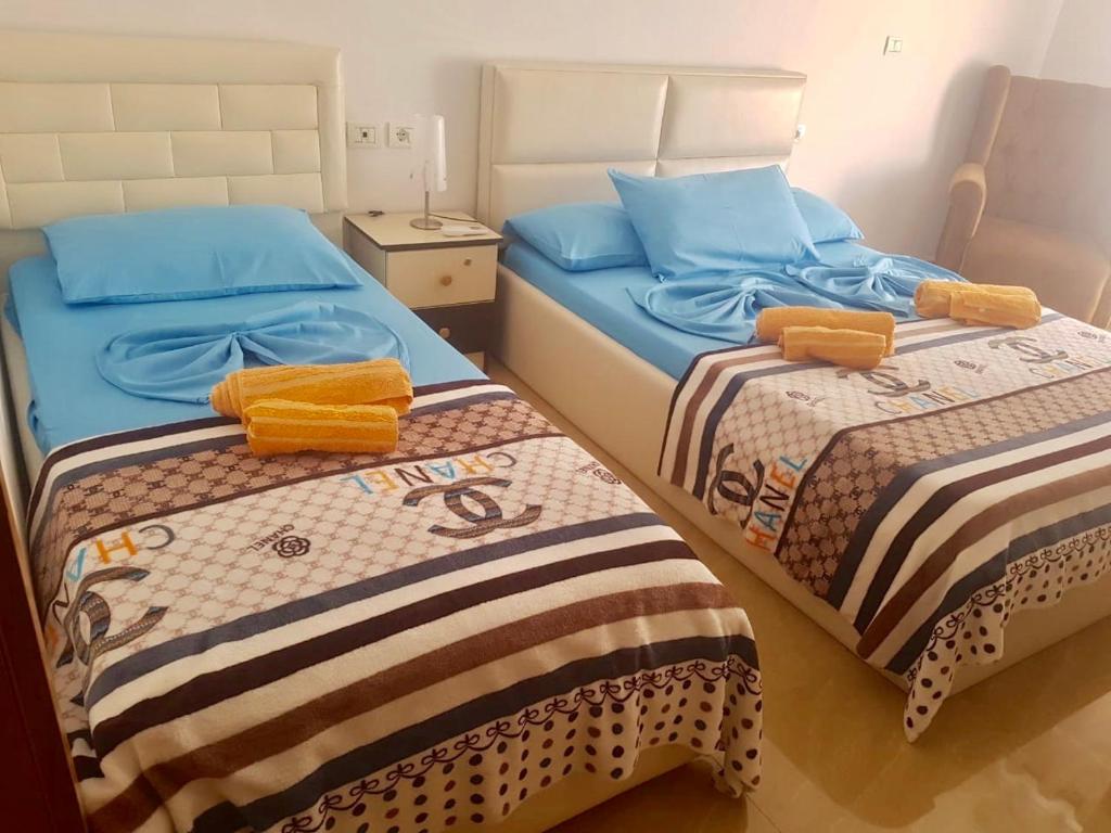 duas camas num pequeno quarto com lençóis azuis em Sixth Apartment em Shkodër