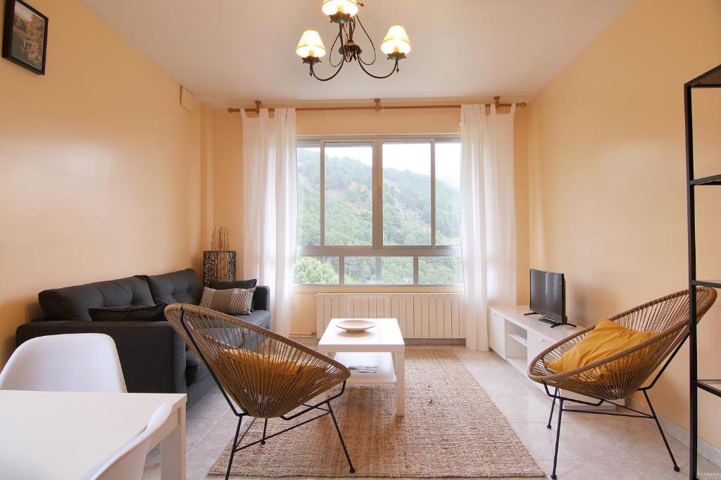 Una sala de estar con un sofá y un televisor. en La Peñita by #cherrygredos, en El Arenal