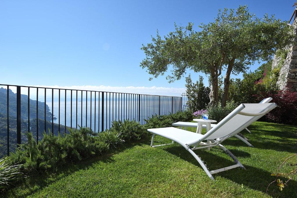 una silla blanca y una mesa en el césped en Villa Gelsomina, en Ravello