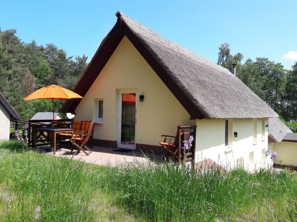 a small cottage with a thatched roof and a patio at Christianshof Insel Usedom in Stoben