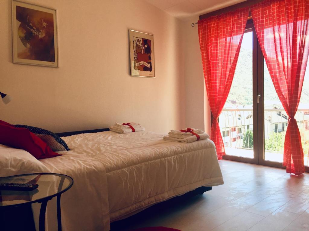 um quarto com uma cama, uma mesa e uma janela em Dimora del cuore em Tirano