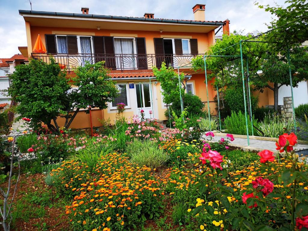 a garden in front of a house with flowers at Naomi's Sunshine in Cres