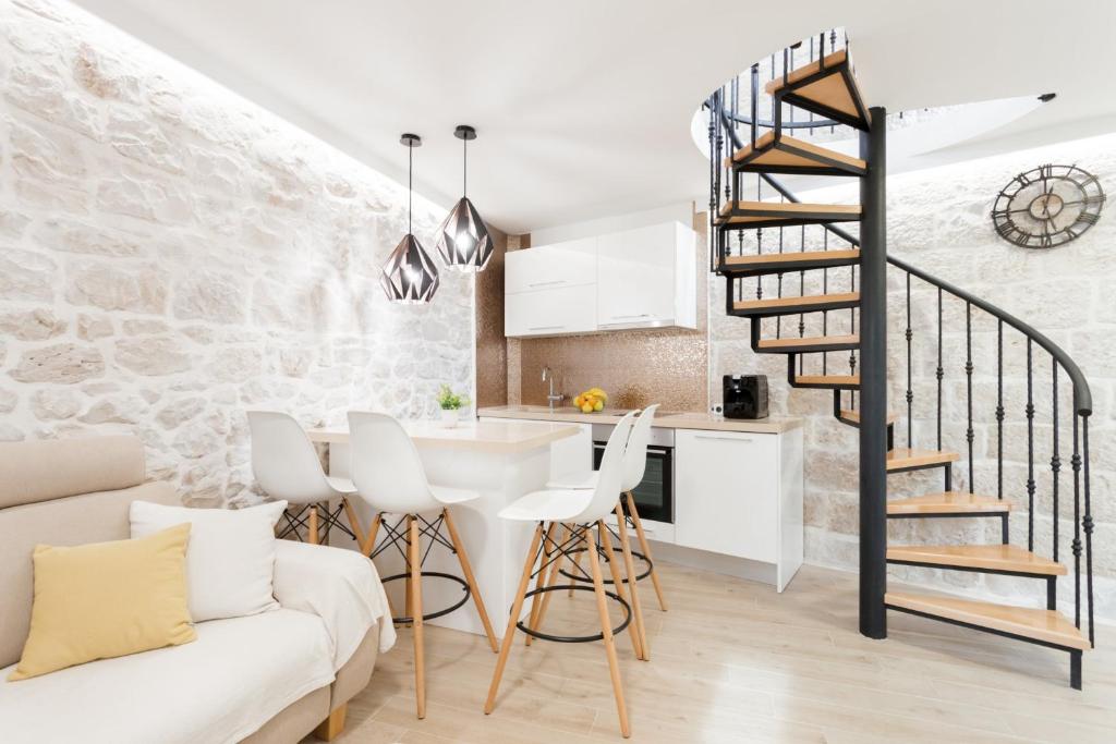 a kitchen and a living room with a spiral staircase at House RokaStone in Split