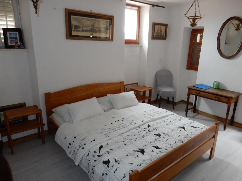 1 dormitorio con cama, mesa y espejo en Studios Jacobus, en Korčula