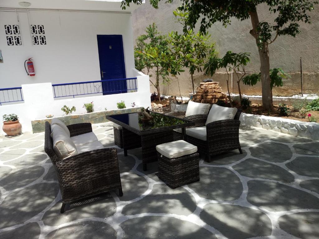 a patio with furniture and a table and chairs at Hotel Poulakis in Skala