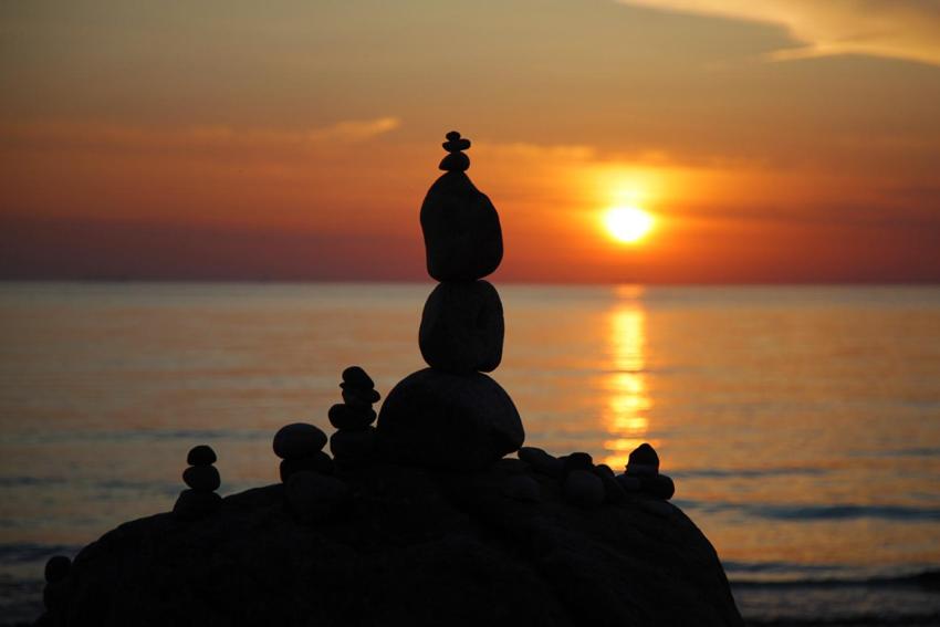 a stack of rocks on the beach at sunset at Karkle Beach Suites in Karklė