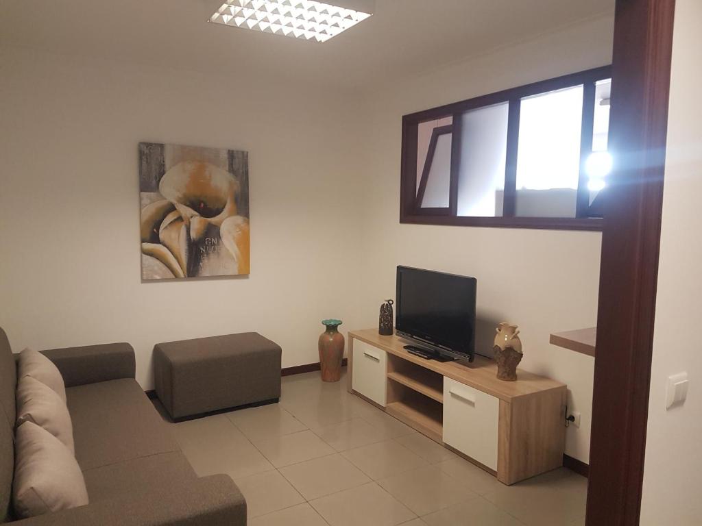 a living room with a couch and a television at Beach and Mountain Paradise in Vila Praia de Âncora