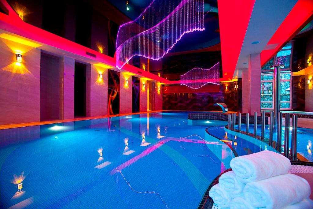 a large swimming pool in a hotel with red lights at KRISTINA Willa & Spa in Szklarska Poręba