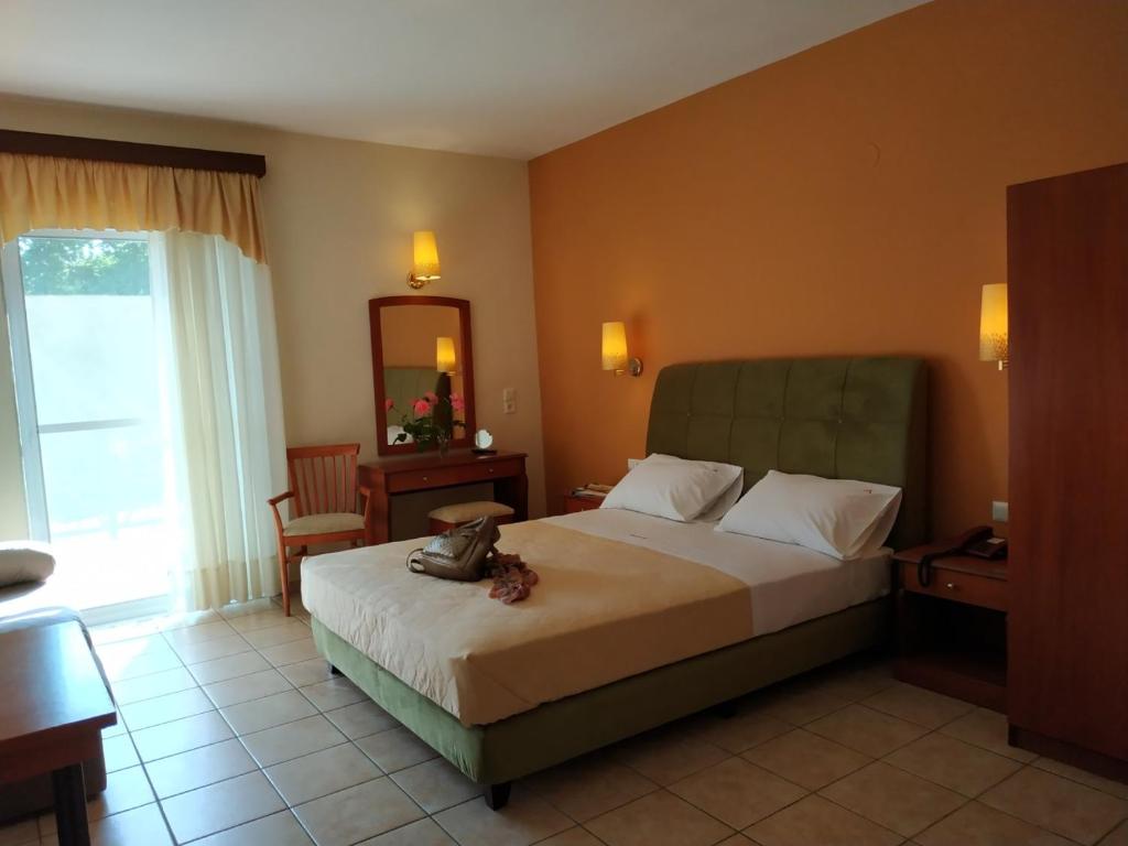 a hotel room with a bed and a mirror at Amalia in Paleo Tsifliki