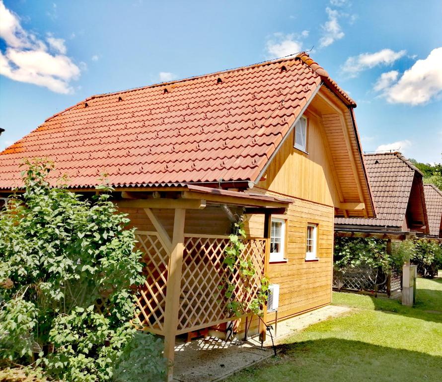 ein Holzhaus mit rotem Dach in der Unterkunft Bella Mura Nature House I26 in Podčetrtek