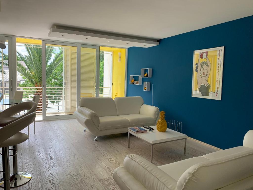 een woonkamer met blauwe muren en witte meubels bij Bingo in Omiš