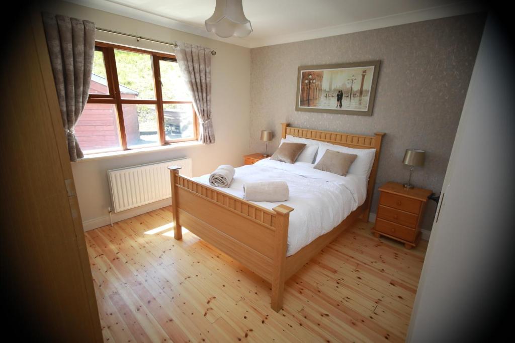 Un dormitorio con una cama grande y una ventana. en Alices Loft & Cottages, en Castleblayney