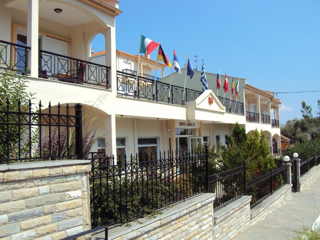 a large building with flags on the balconies at Amalia in Paleo Tsifliki