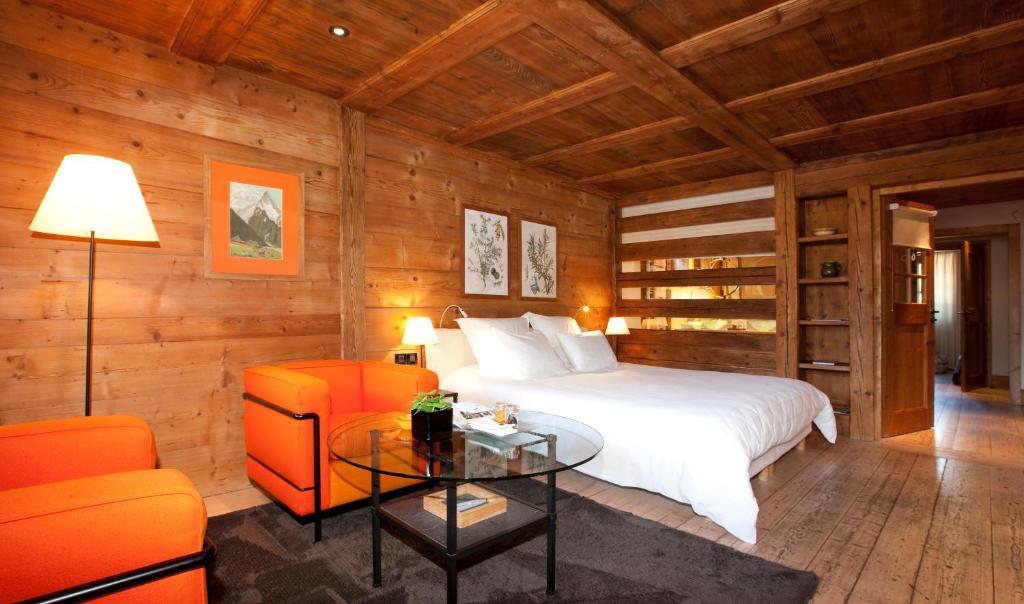 a bedroom with a bed and a table and chairs at Le Hameau Albert 1er in Chamonix
