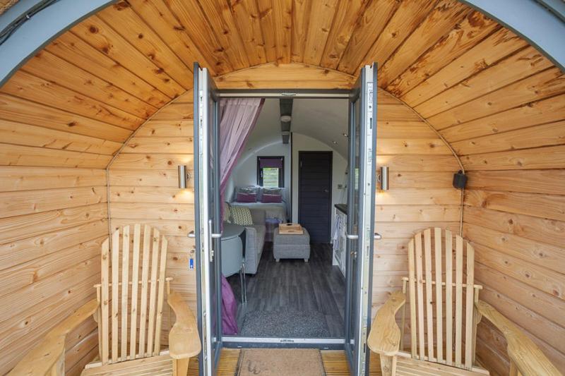 ein Holzzimmer mit 2 Stühlen und einem Eingang in der Unterkunft Tigh Beag na h'aibhne in Broadford
