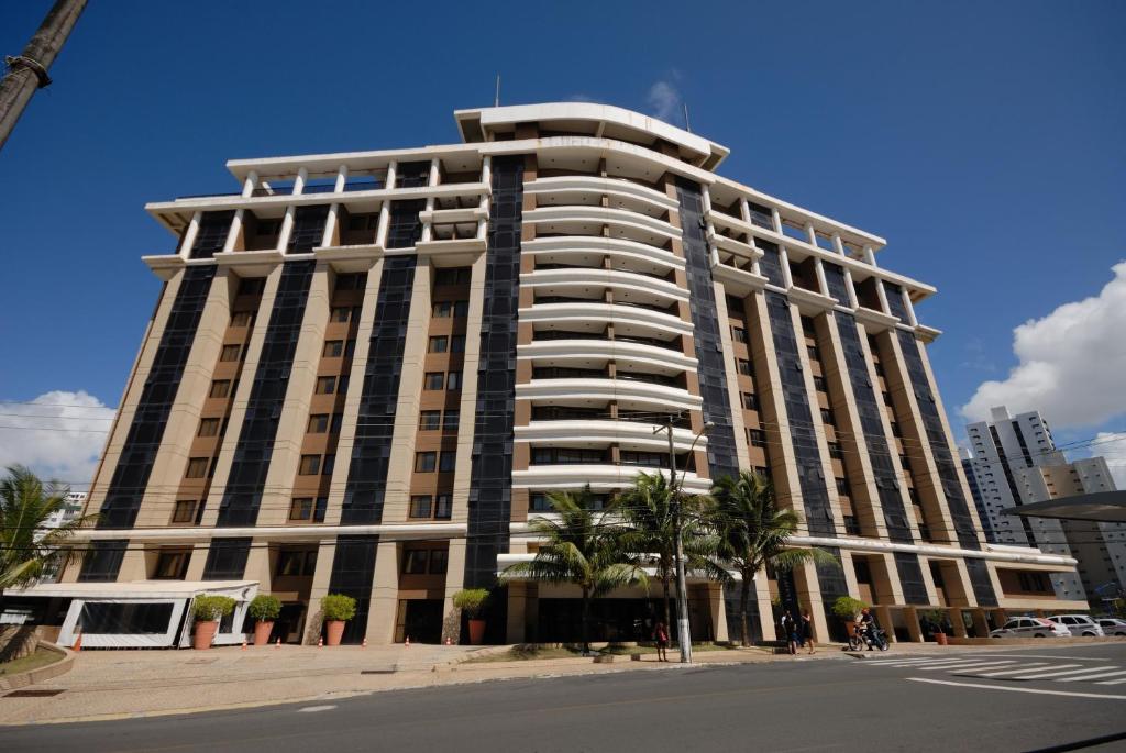 a tall building with palm trees in front of it at Rede Concept - Hotel Salvador in Salvador