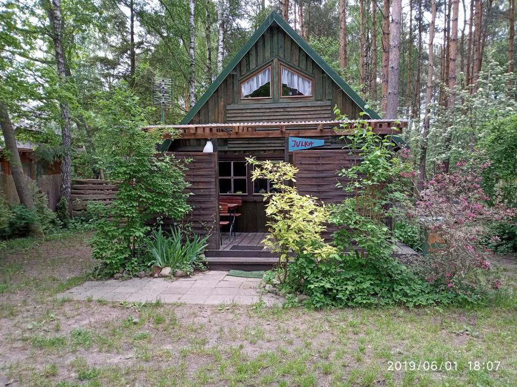 a small wooden cabin in the middle of a forest at Leśna Domek Dębki in Dębki