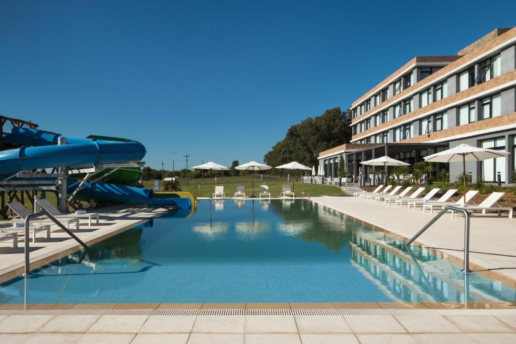 a swimming pool with a slide in a hotel at Salinas del Almiron Resort Termal in Termas de Almiron