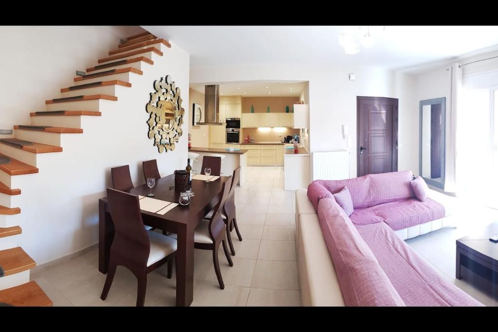 uma sala de estar com uma mesa e um sofá rosa em Marianna's House em Ýpsos