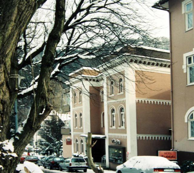 a snow covered building with cars parked in front of it at Hotel Richthofen in Bad Harzburg