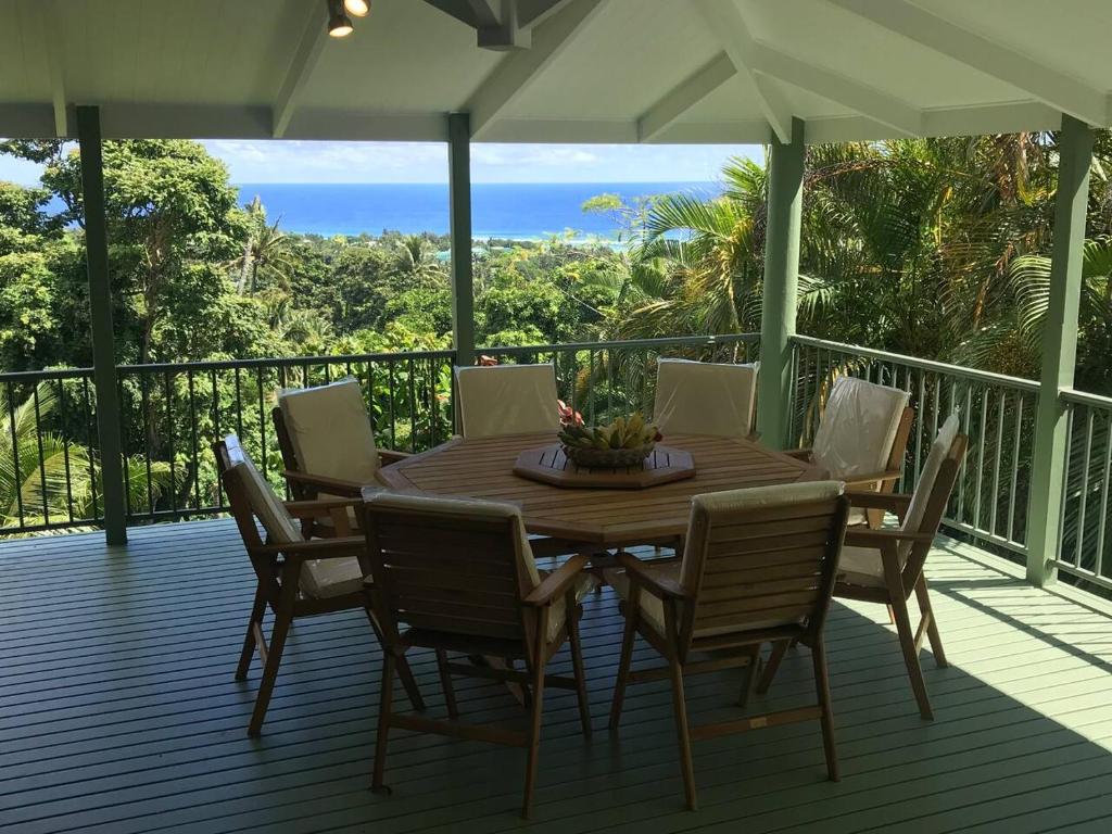 a wooden table and chairs on a deck at Pacific views, tranquil location, extra large home, Navy House 1 in Rarotonga