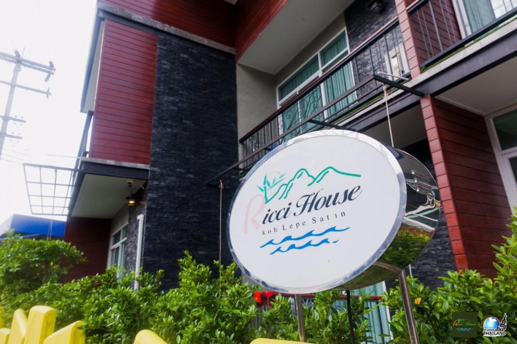a sign for a restaurant in front of a building at Ricci House Resort in Ko Lipe