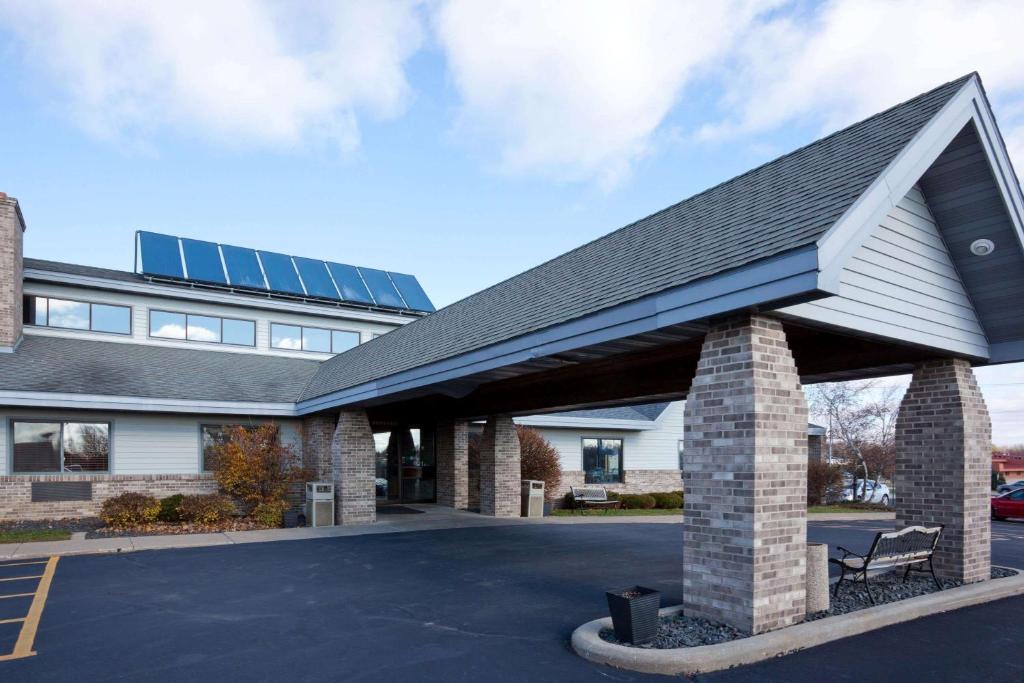 un bâtiment avec un toit et un parking dans l'établissement AmericInn by Wyndham Monroe, à Monroe