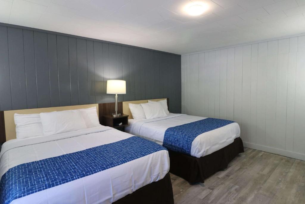 um quarto de hotel com duas camas e um candeeiro em Bishop Inn Downtown Gatlinburg em Gatlinburg
