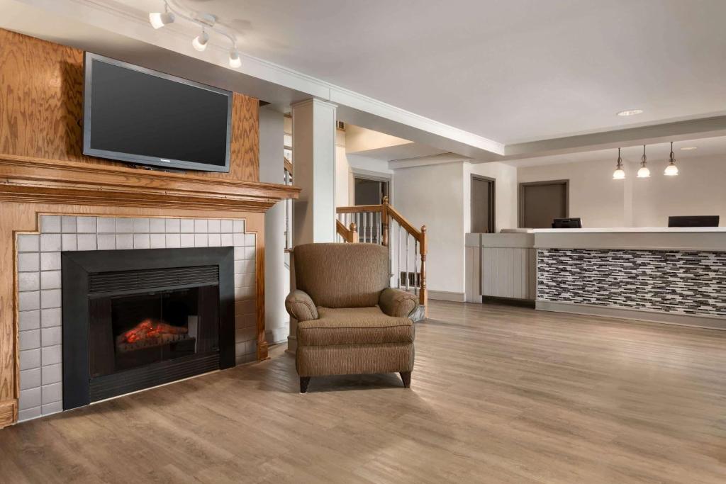 a living room with a chair and a fireplace at Travelodge Suites by Wyndham New Glasgow in New Glasgow