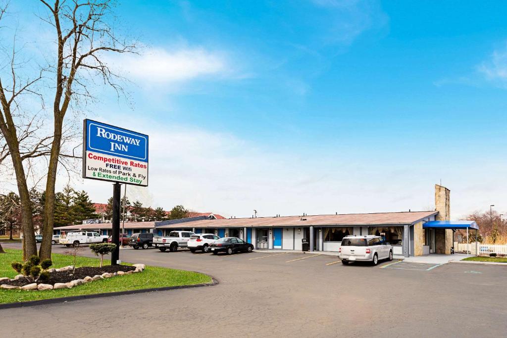 ein Krankenhaus-Gasthaus mit Autos auf einem Parkplatz in der Unterkunft Rodeway Inn Metro Airport in Romulus