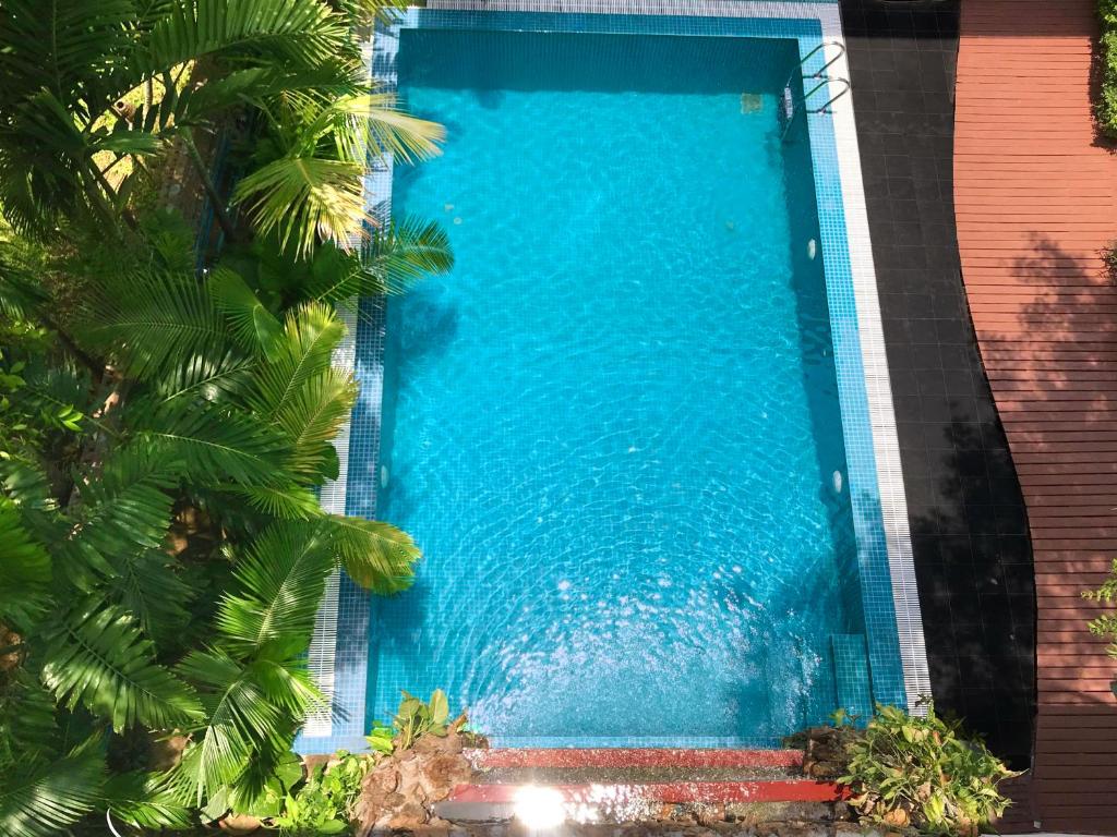 a swimming pool with blue water and palm trees at Royal Bagan Hotel in Bagan