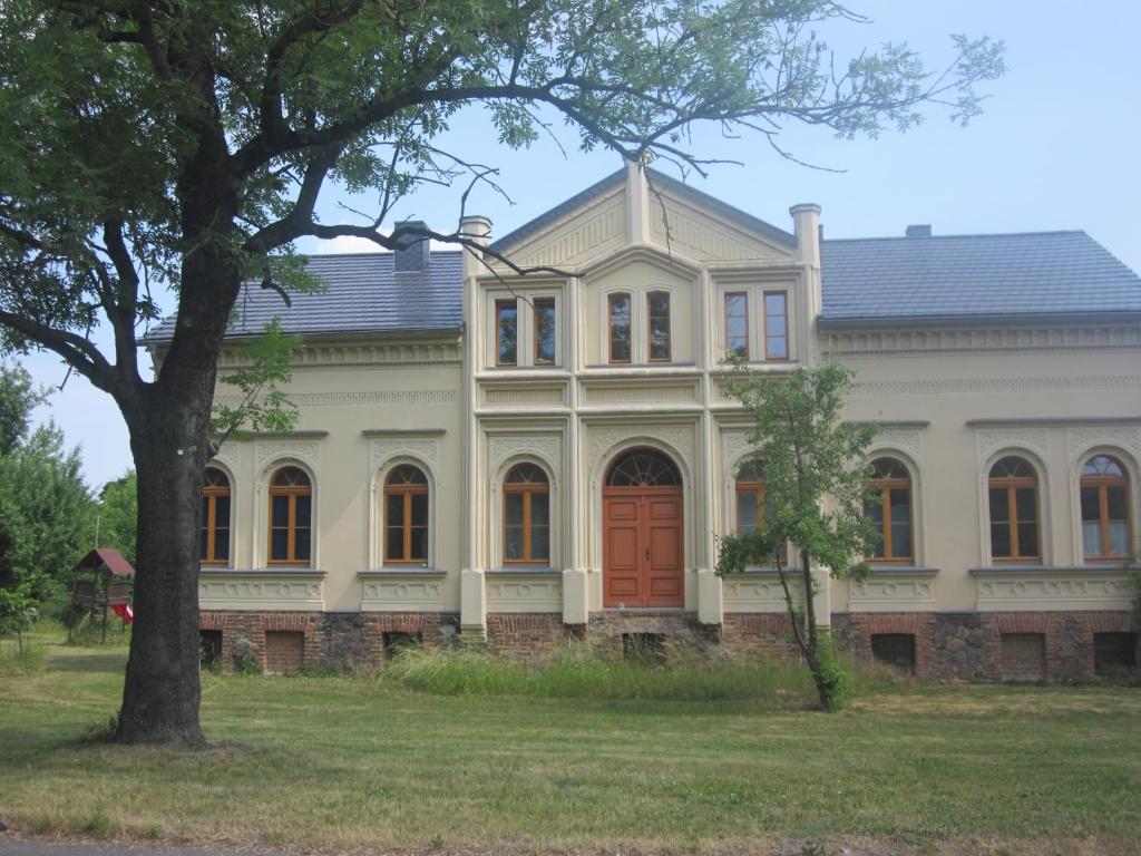 uma grande casa branca com uma porta vermelha em Ferienwohnung Gänseblümchen in Buchholz em Buchholz