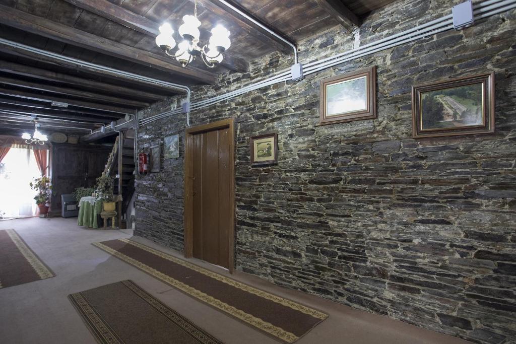 pared de ladrillo con puerta en una habitación con alfombras en A Fonte das Bodas, en Samos