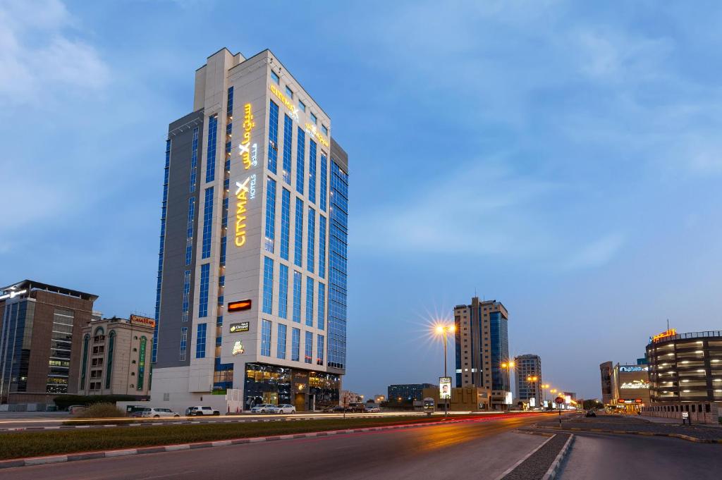 un edificio alto en una calle de la ciudad por la noche en Citymax Hotel Ras Al Khaimah en Ras al-Khaimah